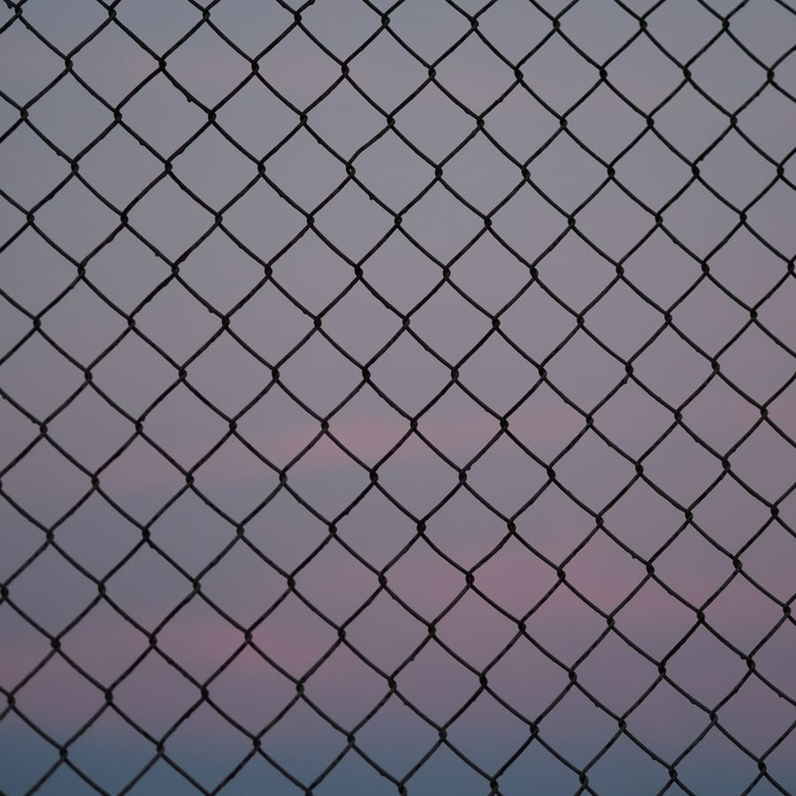 Metal mesh fencing against the sky